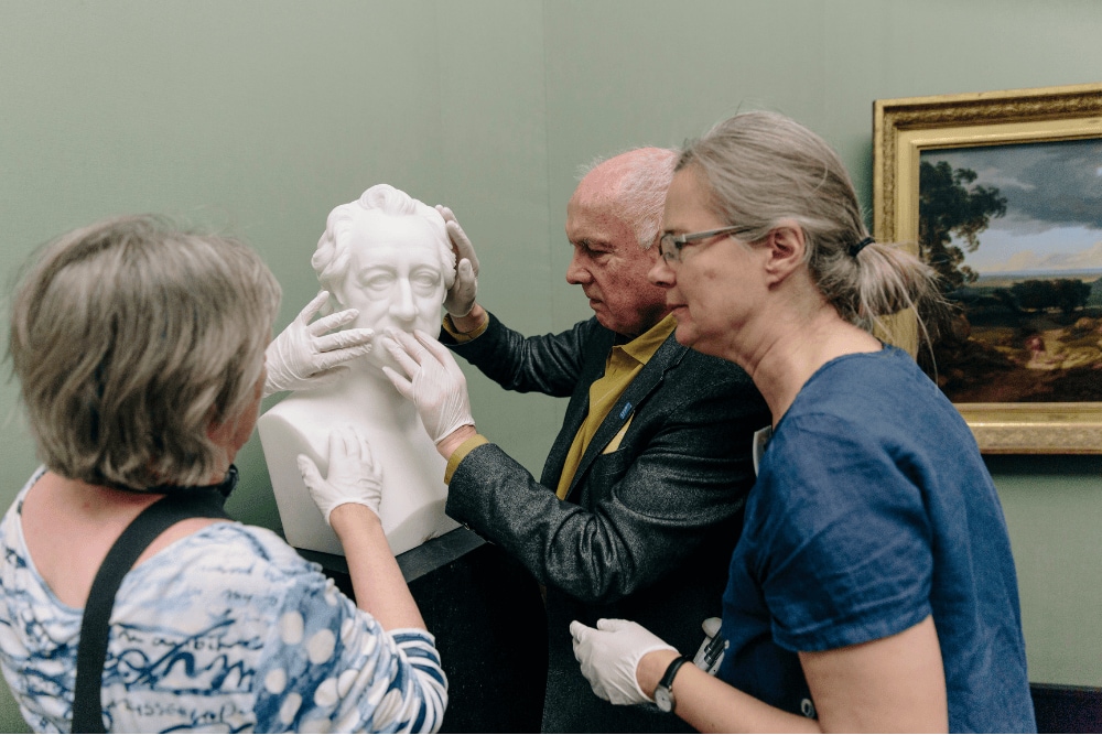 Museumsbesucher ertasten Skulptur